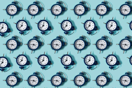 Flat lay retro beautiful new alarm clock on blue color background. Pattern. Topの写真素材