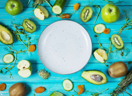Ingredients for cooking smoothie. Organic green vegetables and fruits on wooden blue rustic background. Copy space, flat lay, top viewの写真素材