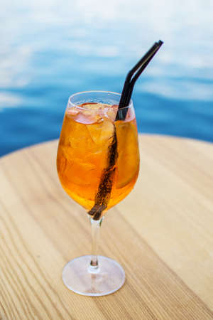 Cold glass of aperol spritz appetizer stand on table near the river