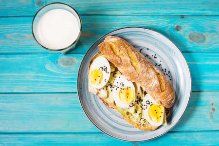 Healthy breakfast - Toast with avocado, egg and glass of milk.の写真素材