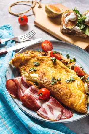 Breakfast mushrooms omelet and sandwich with figs on concrete background.の写真素材