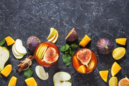 Cocktail fruit sangria with apples, orange, figs, grapes, mint on stone table. Cop y spaceの写真素材