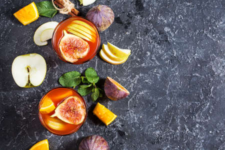 Cocktail fruit sangria with apples, orange, figs, grapes, mint on stone table. Cop y spaceの写真素材