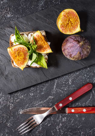 Figs fruit sandwich on a slate plate on a black stone backgroundの写真素材