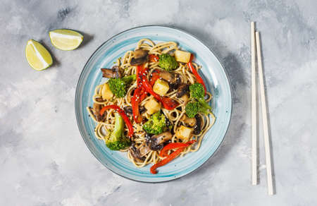 Asian tofu soba noodle bowl on concrete background.