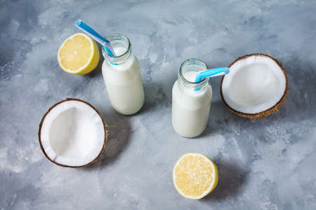 Coconut vegan milk coctail in bottle on concrete background.
