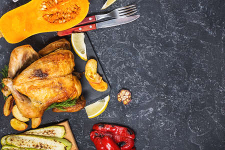 Roasted turkey and grilled zucchini, eggplant and pepper on a rustic stone table. Flat lay. Top view and copy spaceの写真素材