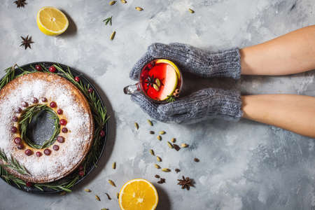 Female hands in mittens holding mug filled with hot mulled wine. Top viewの写真素材