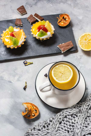 Grey plaid or blanket, cup of tea and cookies on concrete background. Good morning concept.の写真素材