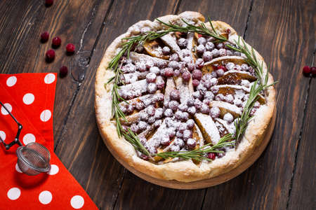 Apple pies with cranberry on wooden background