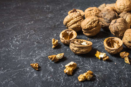 Walnut kernels on a dark stone background.