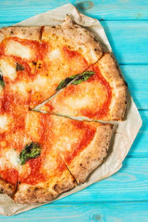 Pizza Margherita on blue wooden table. Traditional italian food.の写真素材