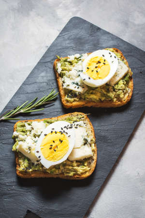 Egg and avocado sandwiches with cream cheese for healthy breakfast on concrete backgroundの写真素材