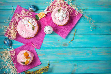Easter composition with orthodox sweet bread, kulich and eggs on blue wood background. Top view
