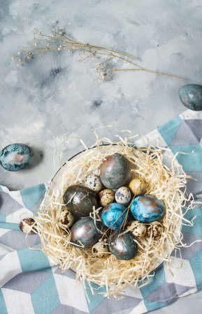 Quail and chicken painted eggs on concrete background. Easter decorations. Top view and copy spaceの写真素材