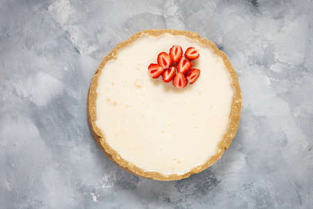 Homemade cheesecake with fresh strawberries on rustic concrete background, top viewの写真素材