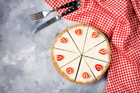 Homemade cheesecake with fresh strawberries sliced on concrete background, top viewの写真素材