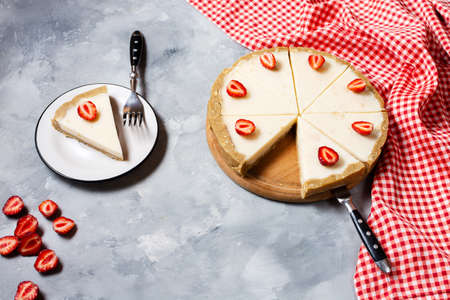 Homemade cheesecake with fresh strawberries sliced on concrete backgroundの写真素材