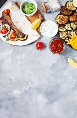 Assorted delicious grilled vegetables and doner kebab on a concrete background. Summer food barbecue. Top view and copy spaceの写真素材