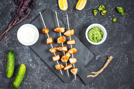 Grilled chicken on bamboo skewers on a black stone background. Top view.の写真素材