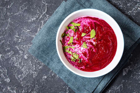 Soup of pureed red beets on black stone background. Top viewの写真素材