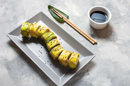 Green dragon sushi roll with eel, avocado, cucumber on concrete table. Traditional asian rice healthy seafood.の写真素材