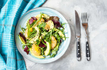 Vegan grapefruit, avocado and arugula salad on concrete background. Top viewの写真素材