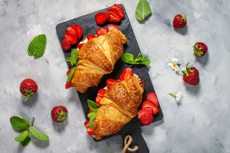 Tasty breakfast. Fresh croissants with strawberries on concrete background. Top vewの写真素材