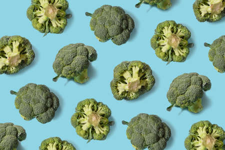 Top view of fresh broccoli isolated on blue background. Minimal concept. Flat lay.