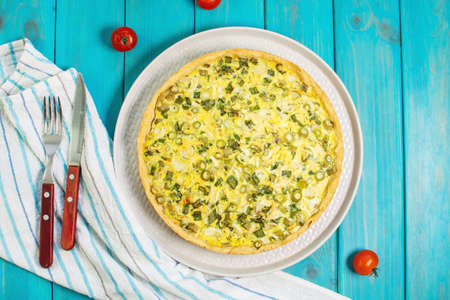 Traditional french homemade onion pie or quiche on blue wooden table. top viewの写真素材