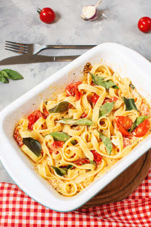 Fetapasta. Trending viral Feta bake pasta recipe made of cherry tomatoes, feta cheese, garlic and herbs in a casserole dishの写真素材