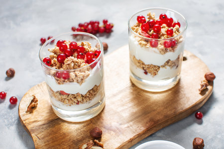 Healthy breakfast menu concept. Morning granola breakfast with berries served with yogurt in glasses.の写真素材
