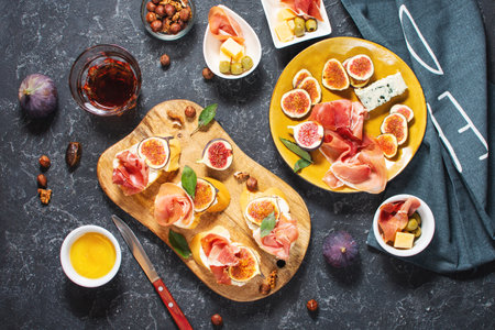 Appetizers board with traditional spanish tapas set. Italian antipasti bruschetta with prosciutto, cream cheese and fig. top view.の写真素材