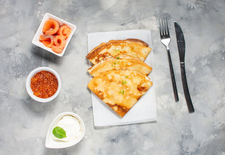Russian thin pancakes or blini with red caviar nd salmon on concrete table. top view.の写真素材