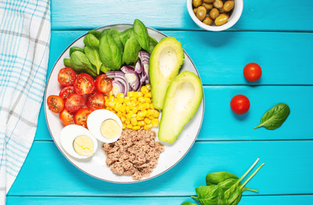 Healthy lunch bowl: egg, tuna, avocado, cherry tomatoes, corn salad, onion. top viewの写真素材