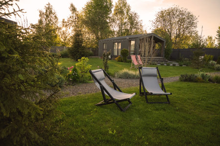 Barnhouse, Barnhouse. Wooden secluded house in the Scandinavian and Finland modern style with beautiful green garden with sun loungers for relaxation. Sunsetの写真素材