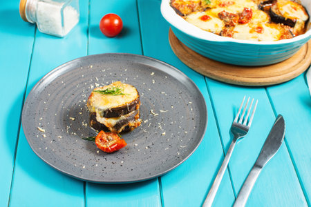 Italian dinner with homemade baked eggplant Parmigiana di melanzane, made with mozzarella, tomato