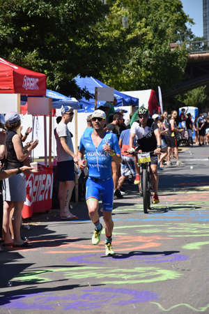 Ironman Hawaii worldchampion Patrick Lange during Ironman Frankfurt 2018 competition. Due to hot weather conditions he is runnning through the feeding zone and grabing for some water.のeditorial素材