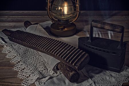 Village life. Old items for washing and ironing at kerosene lamp lightの写真素材