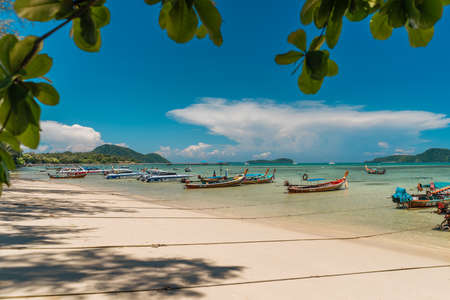 Thai fishing long boats stands on a tropical beach with white sand. Summer vacation and nature travel adventure concept. Summer compositionの写真素材