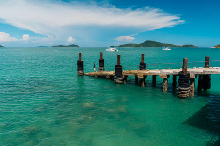 Stairs from the pier to the sea and concrete columns and rubber wheels. Tropical landscapeの写真素材