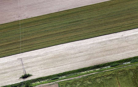 View from airplane to green fields and electric power line