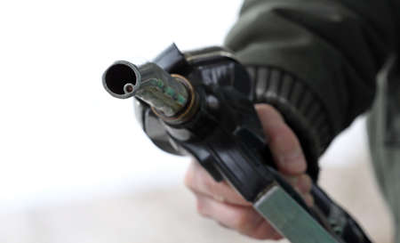 Hand holds gas pump nozzleの写真素材