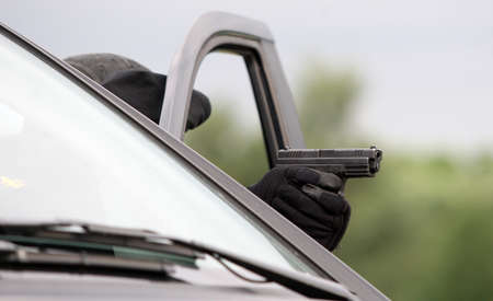 Armed soldiers with a gun behind car