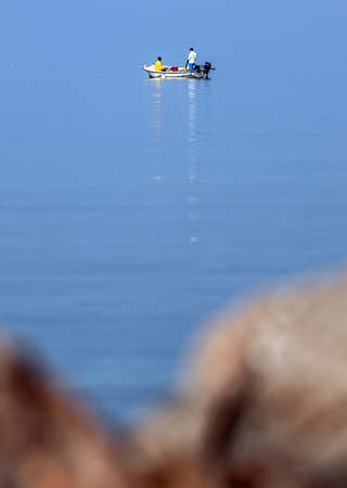 Man in the boat on foggy seeの写真素材