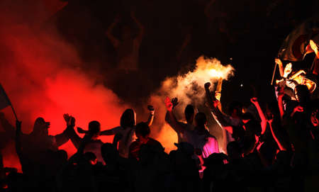 Football hooligans with torches on stadium, fans