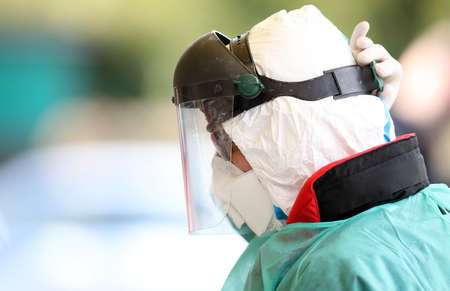 Medical staff member wearing protective suit and mask at drive-through testing point in an effort to curb the spread of COVID-19 (novel coronavirus)の写真素材