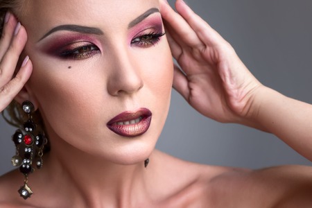 Beauty and Makeup concept with beautiful fashion model woman with black burgundy make-up. Perfect skin. Burgundy gold lips. Trendy smoky eye. High fashion portrait.の写真素材