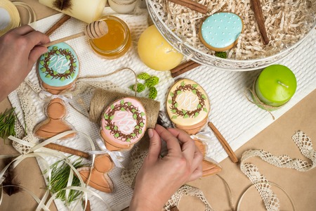 girl prepares gifts, easter honey-cakes, gingerbread in form of eggs,  kitchen celebration spring...