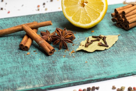 Spices and herbs.  Food, cuisine ingredients photography, fresh cinnamon, cloves, anise, lemon on blue painted wooden board. Mulled wine recipeの写真素材
